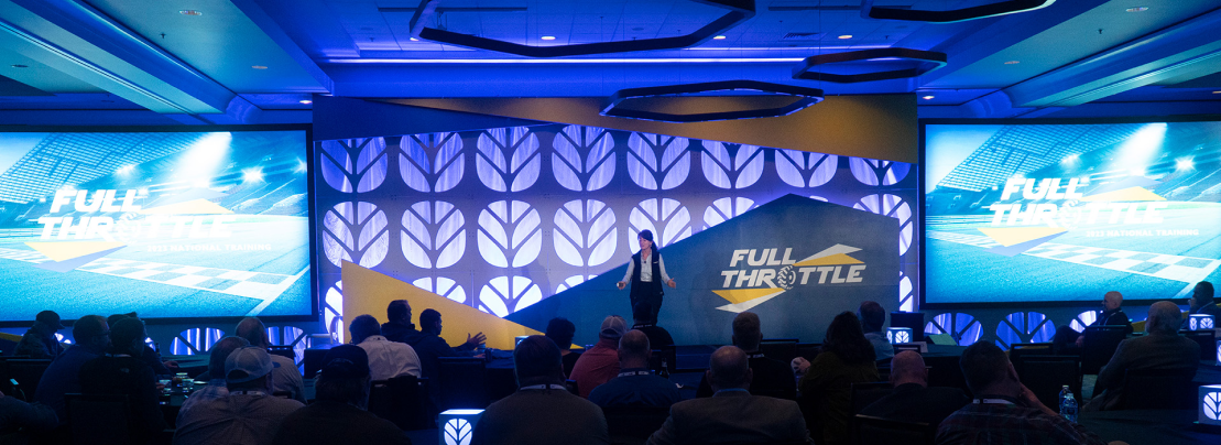 wide shot of a speaker talking at new holland event