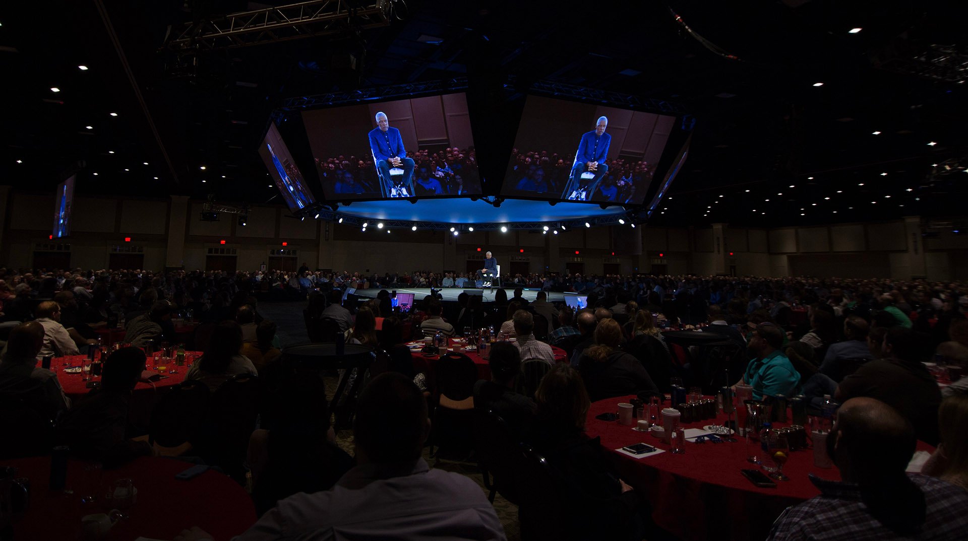 a group of people in a room with a large screen