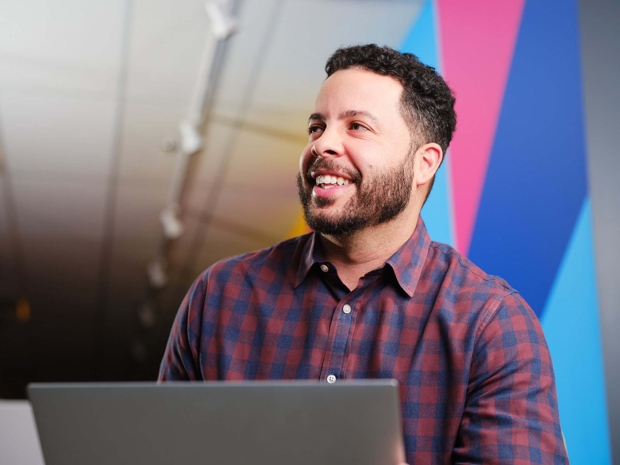 a person smiling while holding a laptop