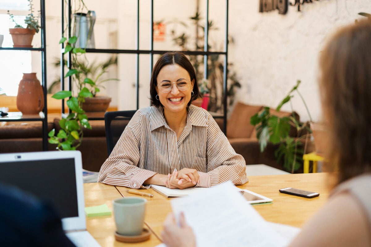 Woman smiling from across the desk.