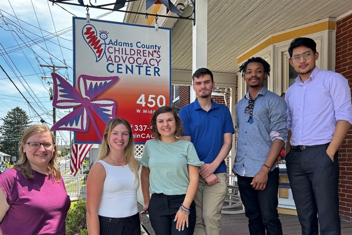 a group of people standing in front of a sign