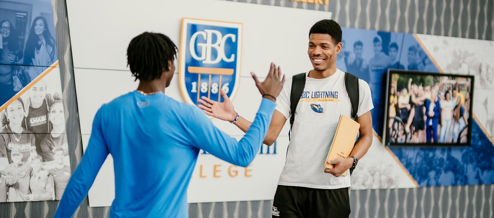 two college students high fiving on campus