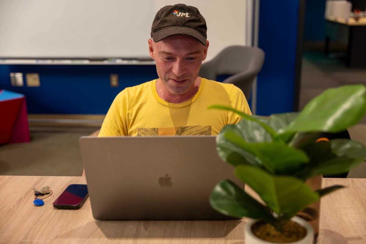 Employee on laptop working at a desk.