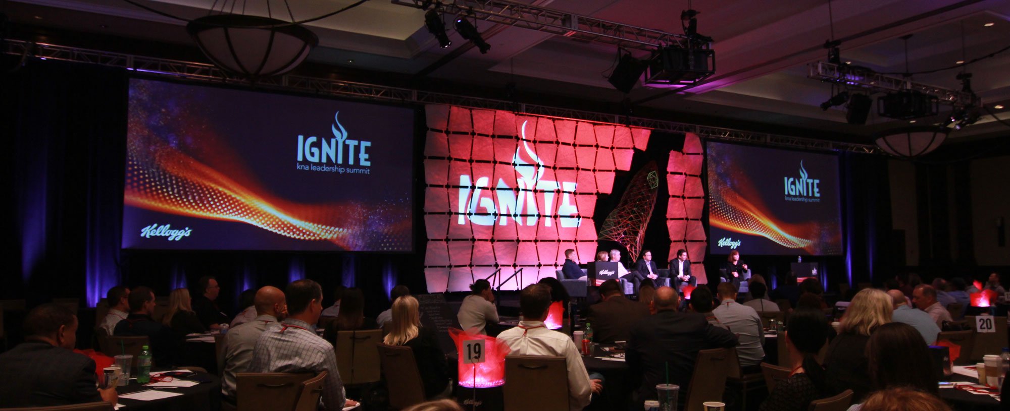 a group of people sitting in front of a large screen