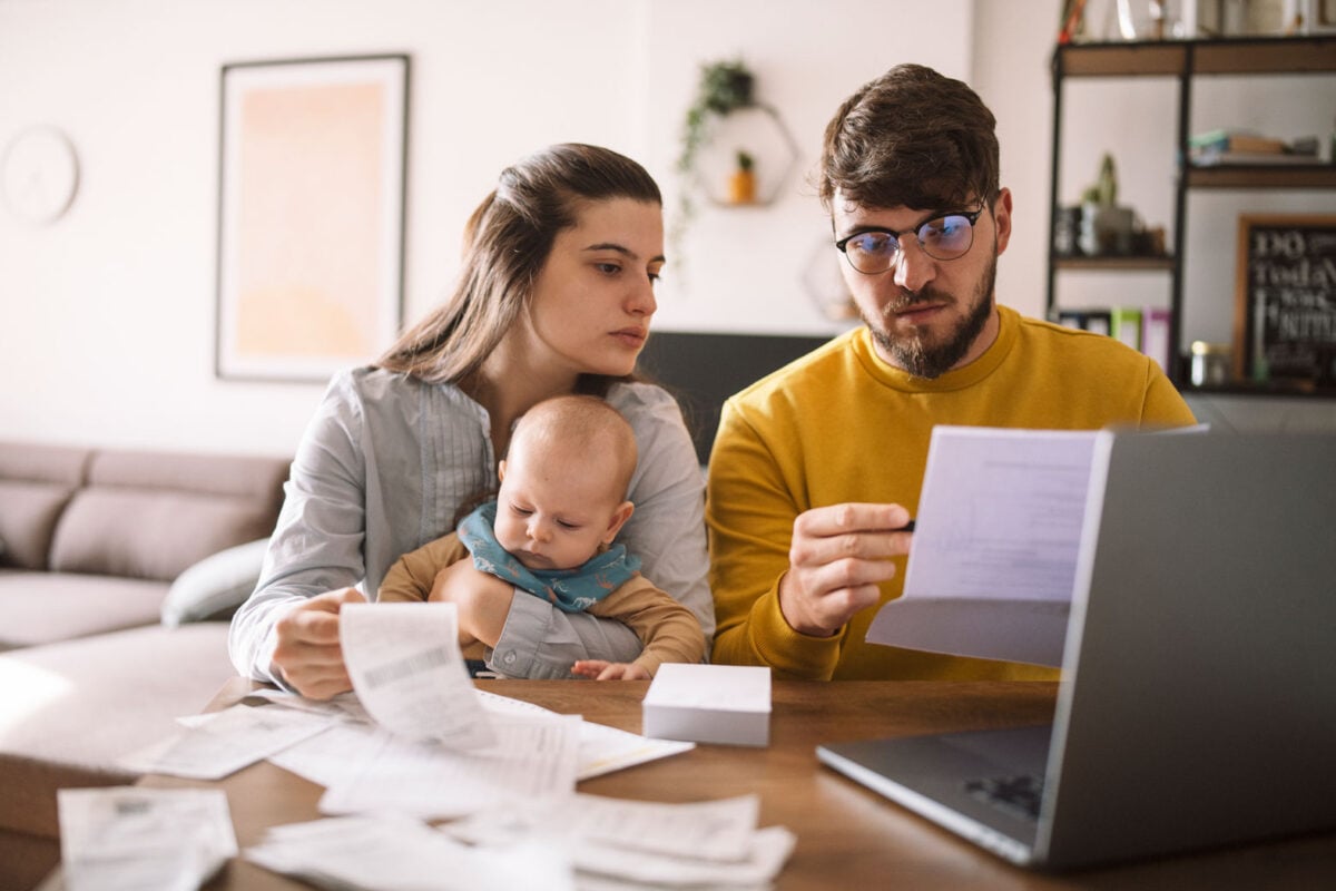 Young parents with baby looking at papers