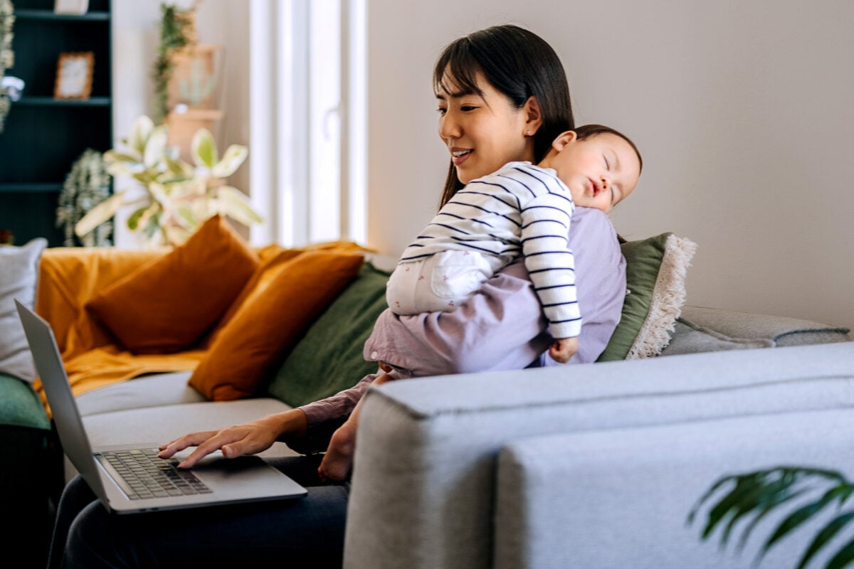 Mother searching online while baby sleeps