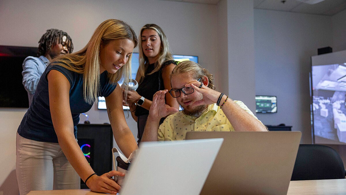 JPL summer interns in front of a laptop collaborating