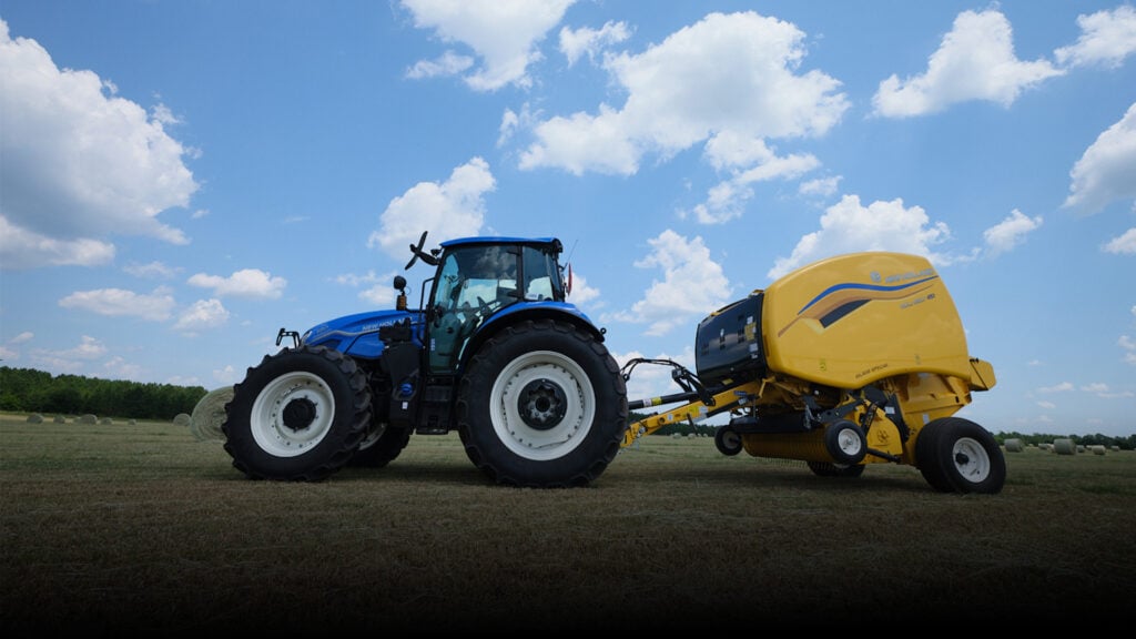 New Holland Roll Tide equipment driving through a field