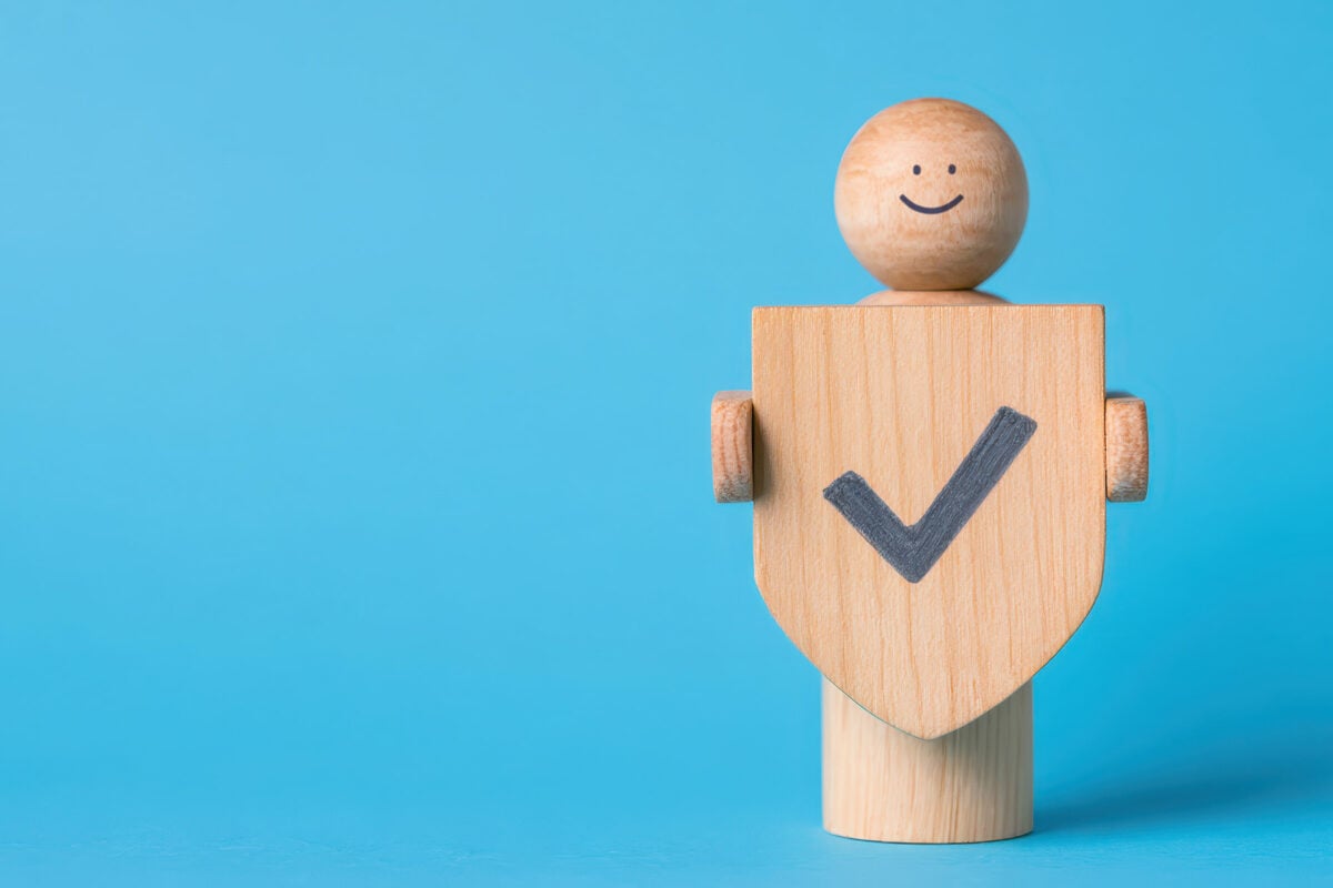 Building trust with wooden figure holding badge of credibility