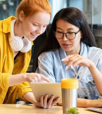 two women looking at a tablet screen