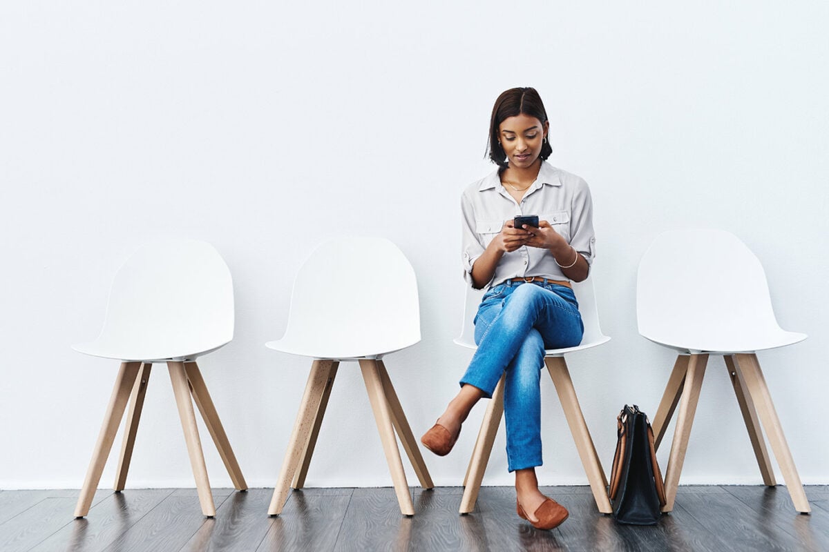 Woman on a device sitting on a chair