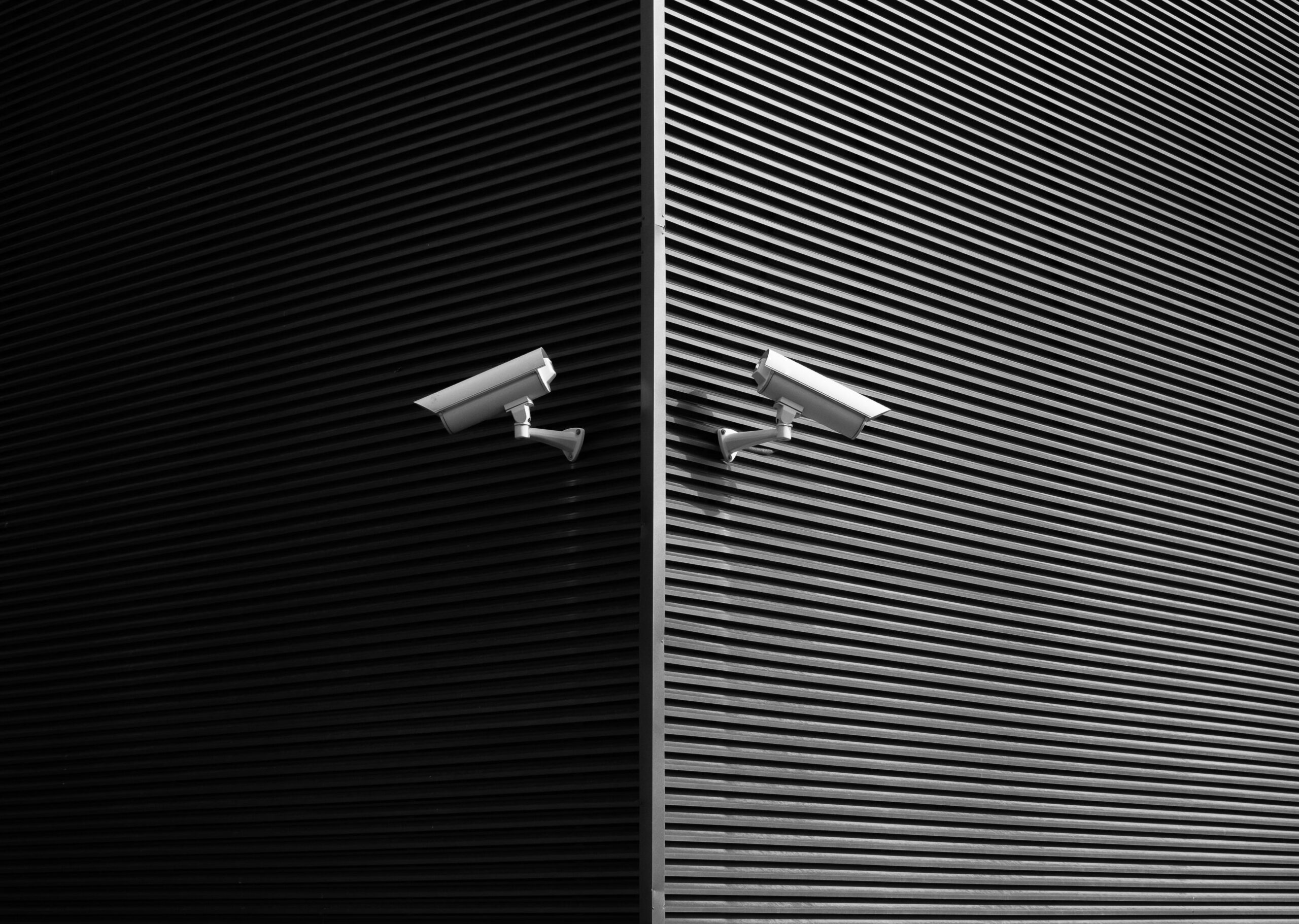 Grayscale shot two surveillance cameras installed on opposing walls