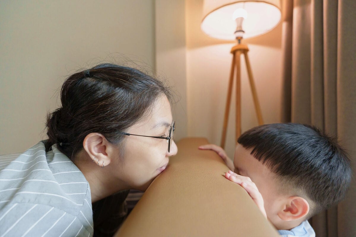 Asian Woman and child playfully interact over couch