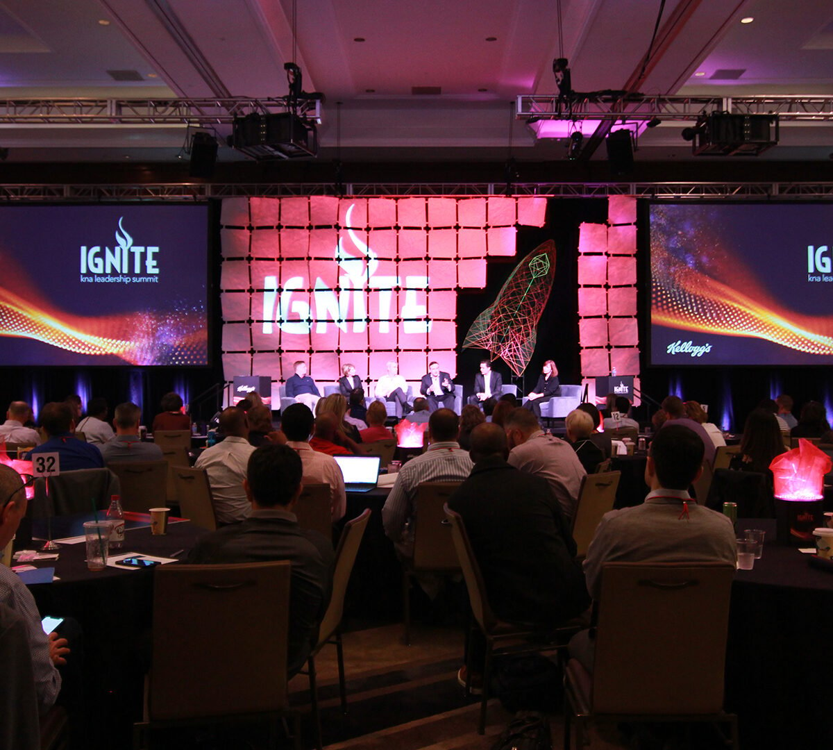 a group of people sitting in front of a large screen