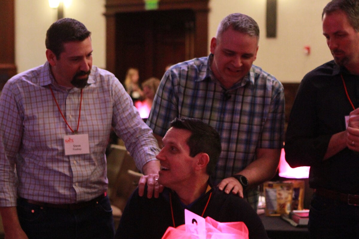 Meeting attendees chatting at a table between sessions.