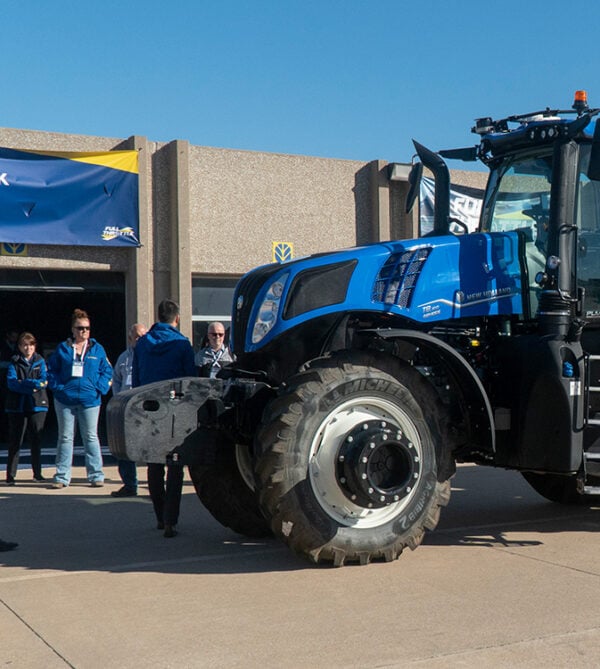 New holland tractor with people around it