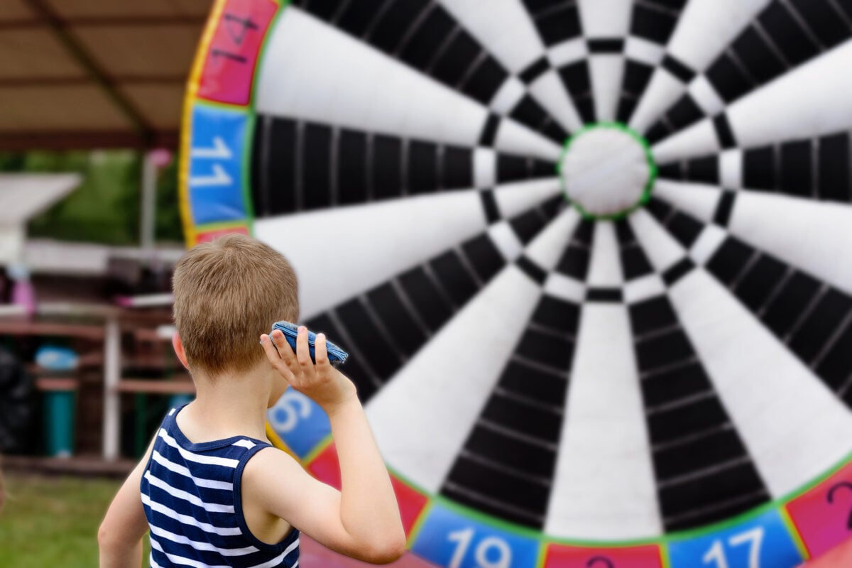 Child playing outdoor - throwing objects to target